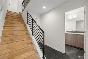 Bamboo staircase up to main level with entry door from garage.