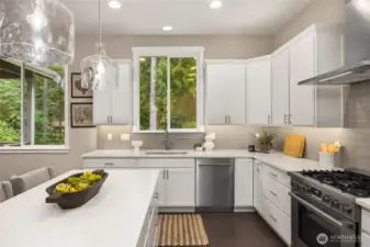The window over the sink looks out to woodlands and the Ferry Dell Trail. Appliances include the Wolf range with propane cooktop and Bosch dishwasher.