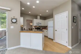 Central kitchen has crisp white cabinetry and pantry