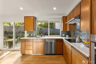 Kitchen overlooks sunny backyard & patio