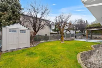 Fenced backyard with sprinkler system and shed