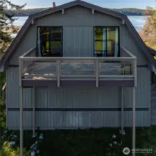 Streetside view of home. Shoal Bay in background; upper deck looks toward Swifts Bay