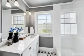 A crisp interplay of light and shadow animates this beautifully restored bath, where checkerboard tile nods to the home's 1930s origins. Awash in natural light, the space offers a daily ritual of renewal—framed by Discovery Park’s ever-changing skies.