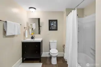 This spacious lower-level bath combines classic simplicity with modern convenience, featuring a full-sized washer and dryer discreetly tucked nearby. Ideal for guest use or daily living, it supports the home’s flexible layout while honoring its enduring sense of calm and care.