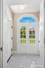 A gracious vestibule welcomes you with original tile underfoot and filtered light through a fanlit transom—details that whisper of 1930s craftsmanship. From the moment you arrive, the home invites you to slow your pace, shed the day, and step into a quieter rhythm shaped by tradition and tranquility.