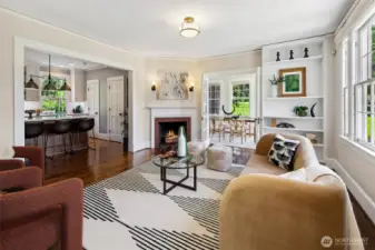Gracefully proportioned and bathed in natural light, the living room centers around a classic wood-burning fireplace—its mantle a quiet witness to generations of warmth and welcome. This is a space for conversation, contemplation, and connection, where the park beyond the windows shapes the mood within.