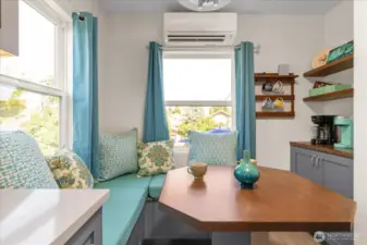 Quaint window niche offers a cozy banquette with table and custom cushions, and a convenient coffee station
