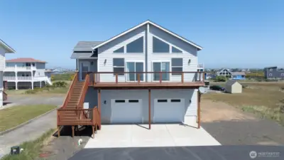 Home features a two-car garage plus RV parking alongside the home, with main living space above to capture the views.