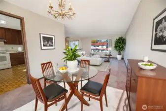 Virtually staged dining room towards the kitchen (on left) and living room.