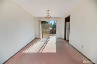 The dining room adjoins with the kitchen on the right and features sliding glass doors to a large deck and backyard.