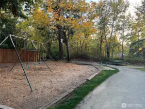 Another photo from this private community park showing the swing set and some of the benches, tables, and trails.