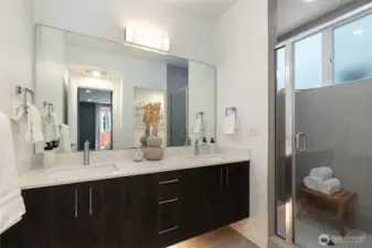 Double vanity bathroom with a walk-in shower, large window and a tucked away loo.