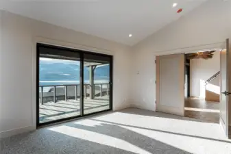 Primary bedroom with large glass sliding door opens to the large deck.