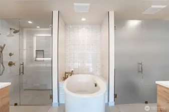 Modern jetted self-cleaning soaking tub is the focal point of the en suite primary bathroom.