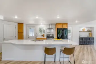 Step into a beautifully designed kitchen centered around a striking 12ft quartz island, an entertainer’s dream with plenty of room to gather, dine & connect. The expansive layout flows effortlessly towards a nearby wet bar.