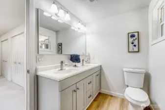 Primary bathroom with double sink, tile shower. Primary bedroom has custom double closets with lots of storage.