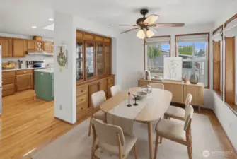Beautiful formal dining area with ceiling fan, large window, and built in china hutch