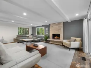 This open- concept living room serves as the heart of the home, featuring elegant, exposed beams and chic recessed lighting.