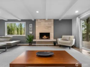 Travertine fireplace serving as a sophisticated focal point in the main living space. Enjoy the large picture windows inviting abundant natural light and frame the surrounding greenery.