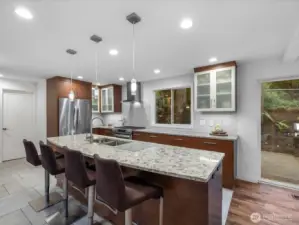 Gourmet kitchen features high-end finishes, including sleek quartz countertops, stainless-steel appliances, and custom soft-close drawers paired with elegant recessed and pendant lighting.