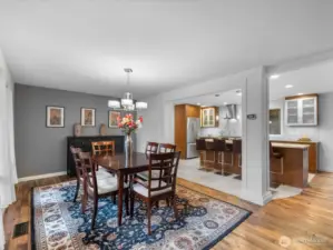 From the main entrance, a seamless view unfolds into the dining area and beautifully remodeled kitchen, highlighted by stunning reclaimed oak hardwood floors that add warmth, character, and timeless elegance.