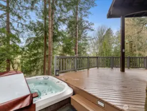Jacuzzi hot tub overlooking the forest stays with the property, creating a spa-like outdoor escape.