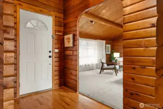 Rich wood log walls on main floor welcome you inside at front entrance