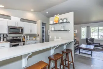 Galley kitchen with extra wide aisle, breakfast bar, Quartz counter tops and stainless steel appliances..