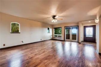 Large living room with french doors to head out to the front patio or down the steps to the outdoor  fireplace!
