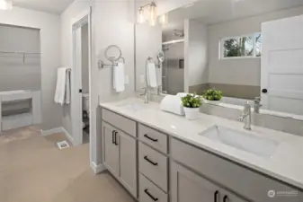 Primary ensuite bathroom with dual vanities and private water closet.