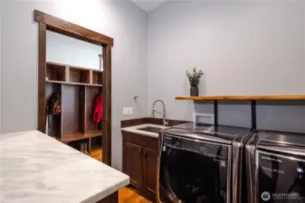 Laundry room with entrances from the primary closet and the hallway