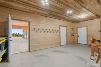 Tack room off shop with shelving, bridle and saddle racks.