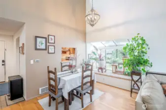 Dining room features a beautiful chandelier and a solarium window nook. Perfect place to showcase your plants!