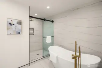A luxury bathroom can be found in the primary suite with glass doors & full soaking tub