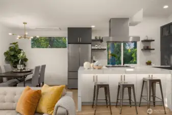 The kitchen is a true showpiece—sleek waterfall island, quartz countertops that shimmer in the light, designer pendant fixtures, and a seamless flow that invites conversation while you cook and host.