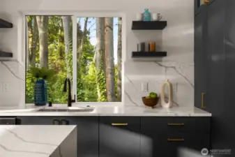 A glimpse into the home’s artistry—sleek open shelving, matte finishes, and subtle contrasts come together to create a kitchen that is both bold and beautifully balanced.