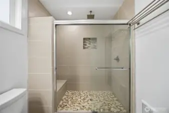 Primary walk in shower with fountain shower head. and seat.