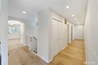 Here you can see the new imported, wide plank flooring with underfloor heating.  The first door on the left is the guest bathroom.  The second door on the left is the Utility room.  The third and last door on the left is the home office.  The Primary bedroom and bath are both located at the end of the hall on the right.