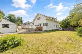 Large, flat backyard surrounded by mature plants with room for more!