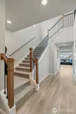 Grand stairway leading upstairs to primary + 3 additional bedrooms and upstairs laundry