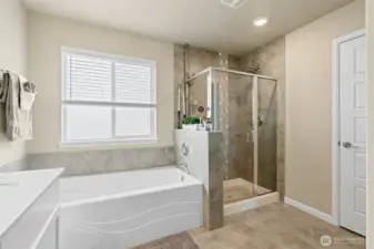 Primary bathroom soaking tub, separate shower and linen closet for extra storage