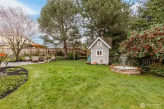 Level fully-fenced yard includes beautiful mature landscaping and a serene fountain