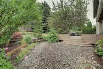 The side yard includes terraces flower beds for year 'round blooms.