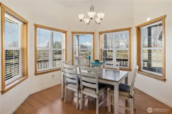 Bay windows frame the dining room table, filling the space with abundant natural light.