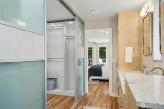 Contemporary primary bath features custom cabinetry and a gorgeous closet.