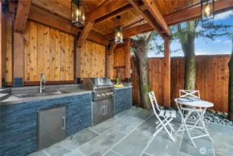 Steps from the hot tub is this fabulous outdoor kitchen. Note all the attention to detail with the use of wood and stone to blend with the surrounding environment.