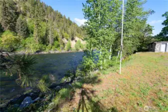 View of the river from the building site. Historic stone structure has power & could be a studio, sauna, or storage shed.