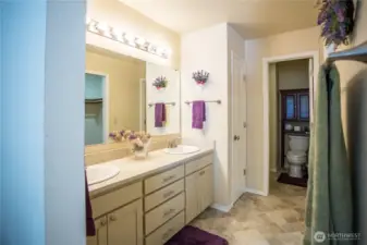 Spacious primary suite includes double sinks, a shower, and a walk-in closet.
