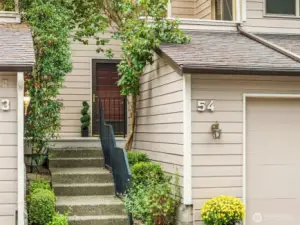 Private entry framed by greenery and landscaped setting.