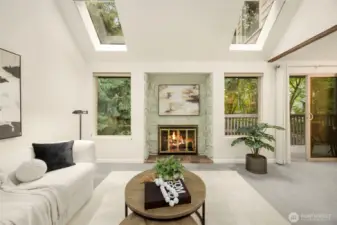 Bright living space with fireplace, treetop views, and seamless flow to the private deck.